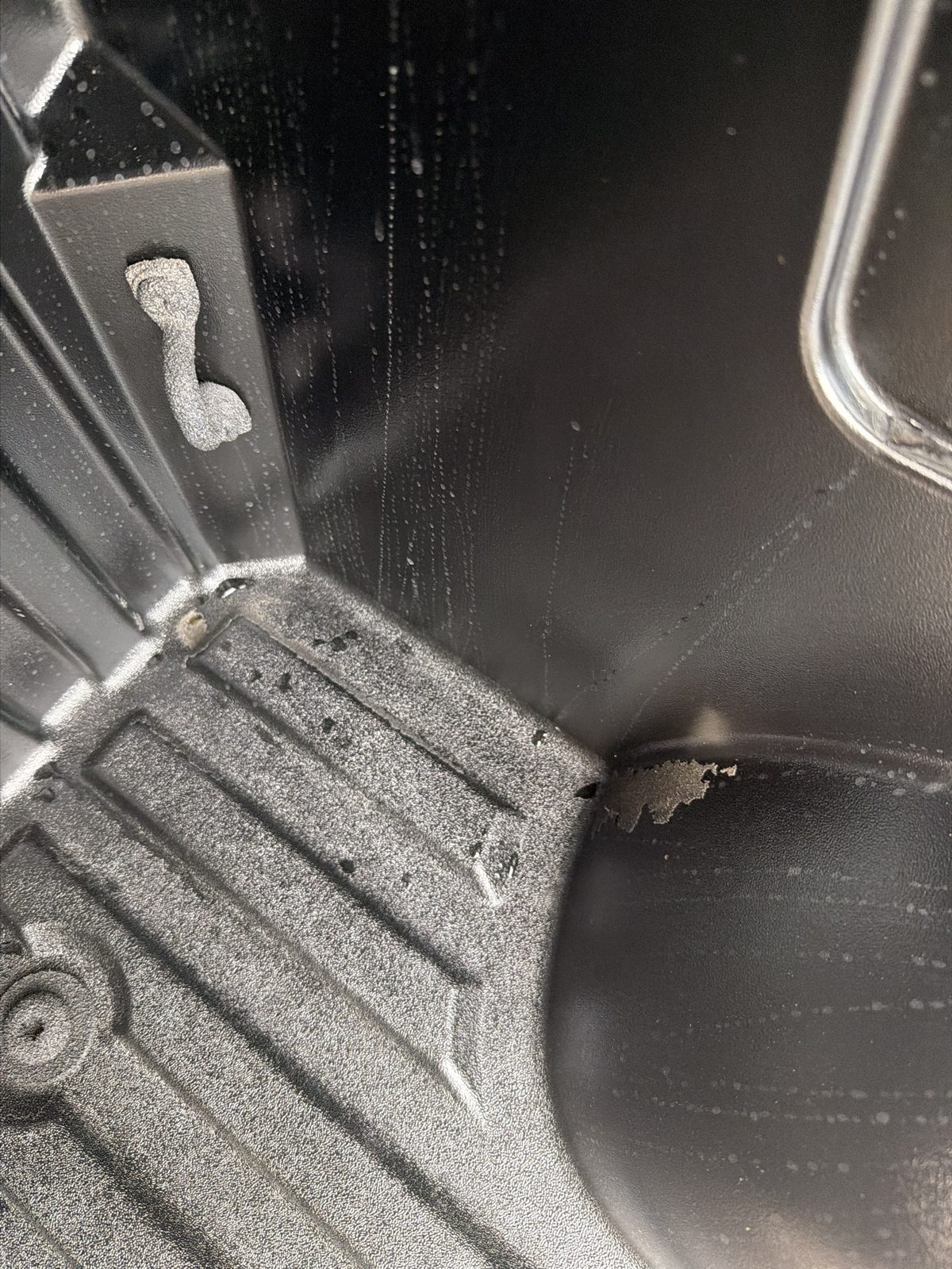 Bed liner peeled away at the wheel hump, bare bed showing