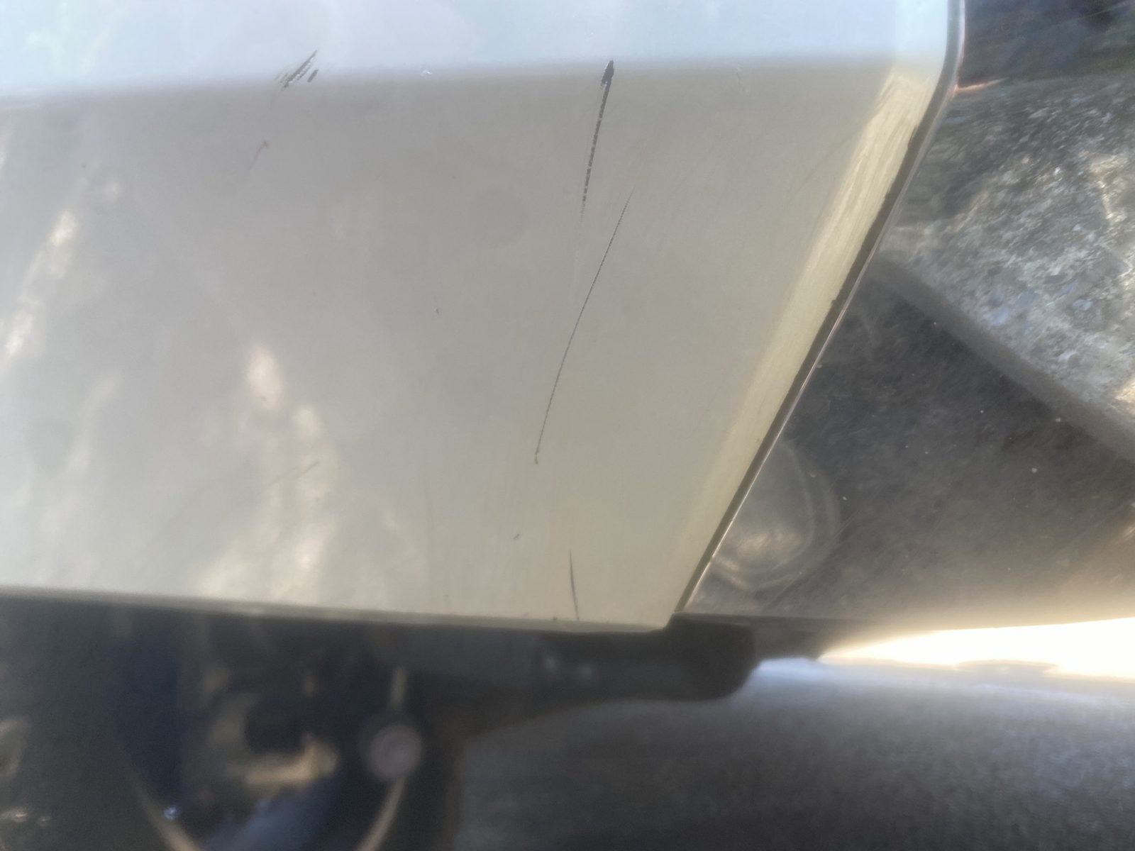 Deep scratches through the paint on a lower body panel