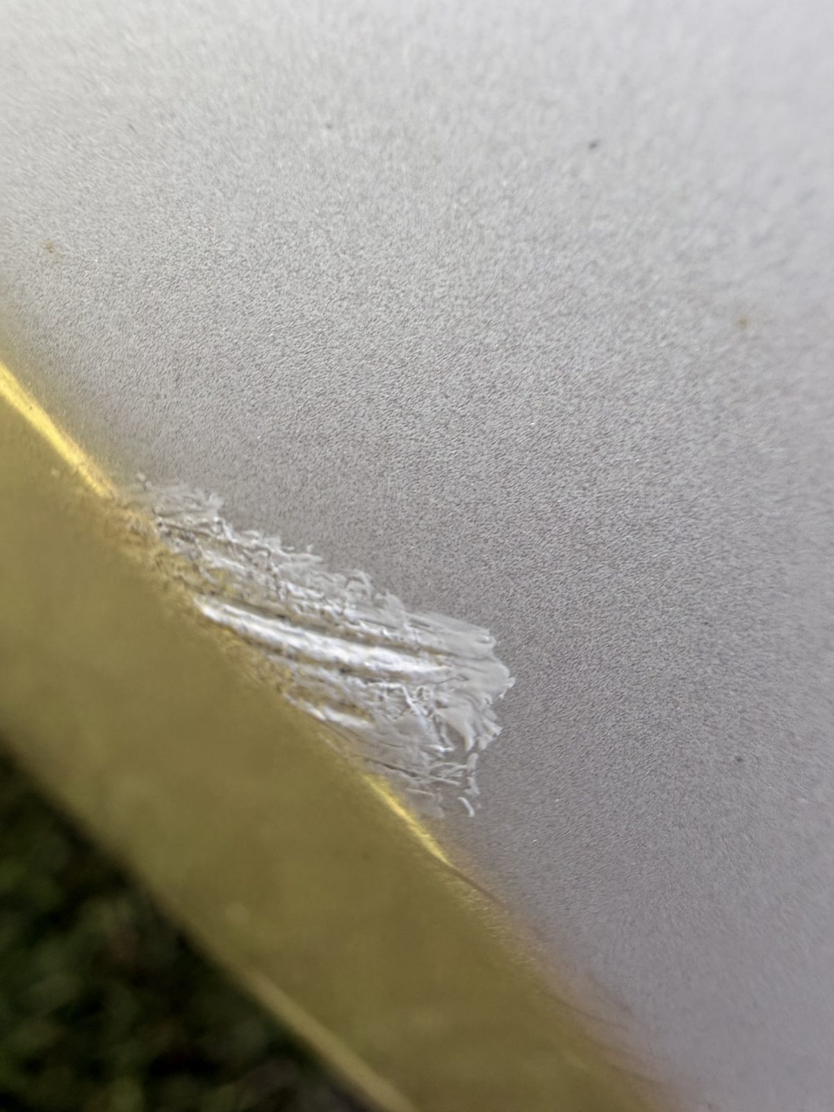 Close-up of a scrape through the paint on the bumper edge